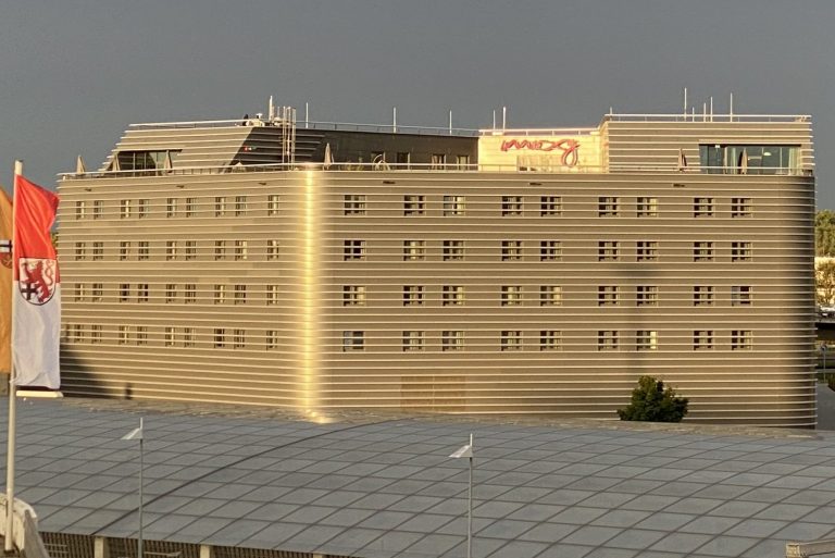 Hotel Moxy Köln Airport - Ansicht von der umgebenden Flughafenstraße.